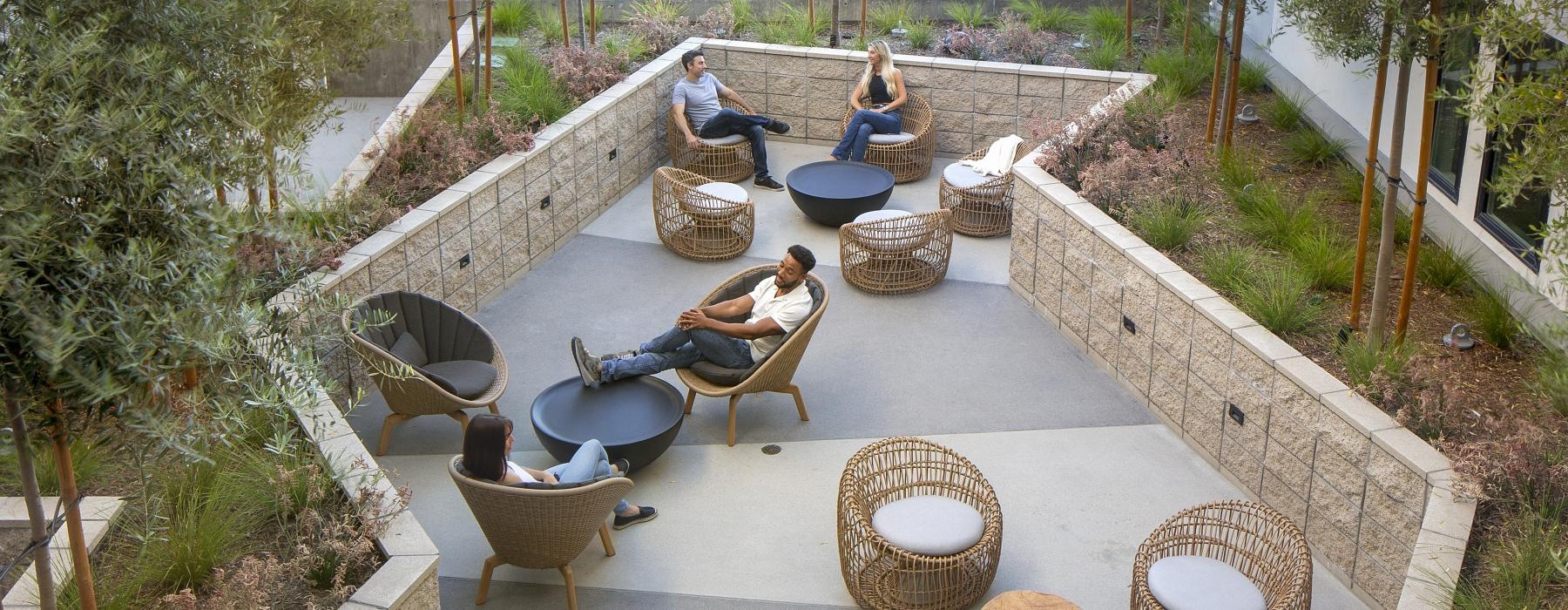 a courtyard with a table and chairs and a couple people sitting on it