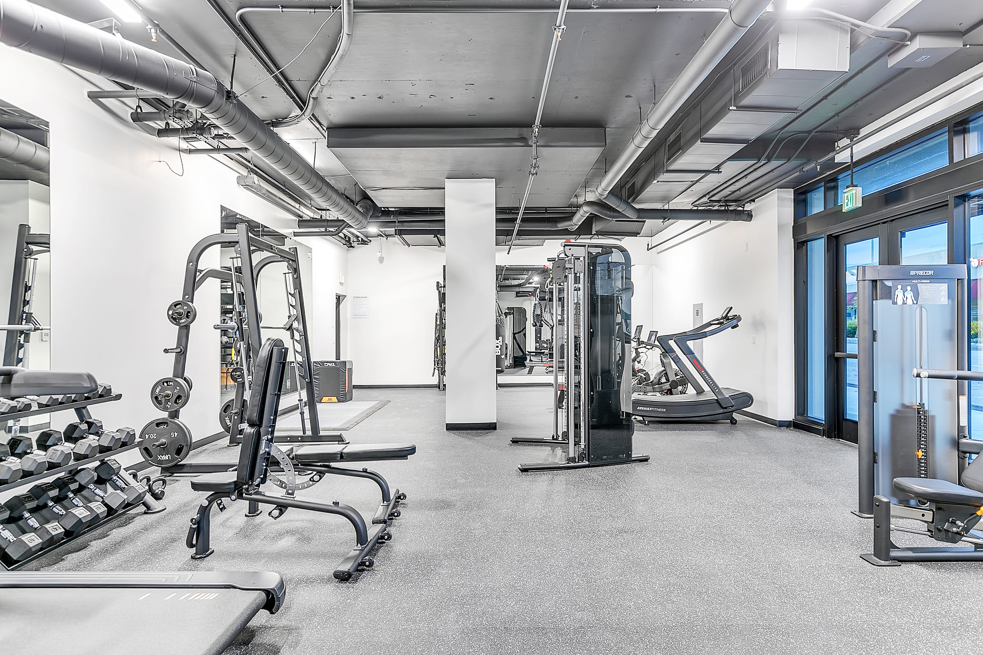 A multifamily apartment with a gym room equipped with a variety of machines and equipment called The Rinrose.