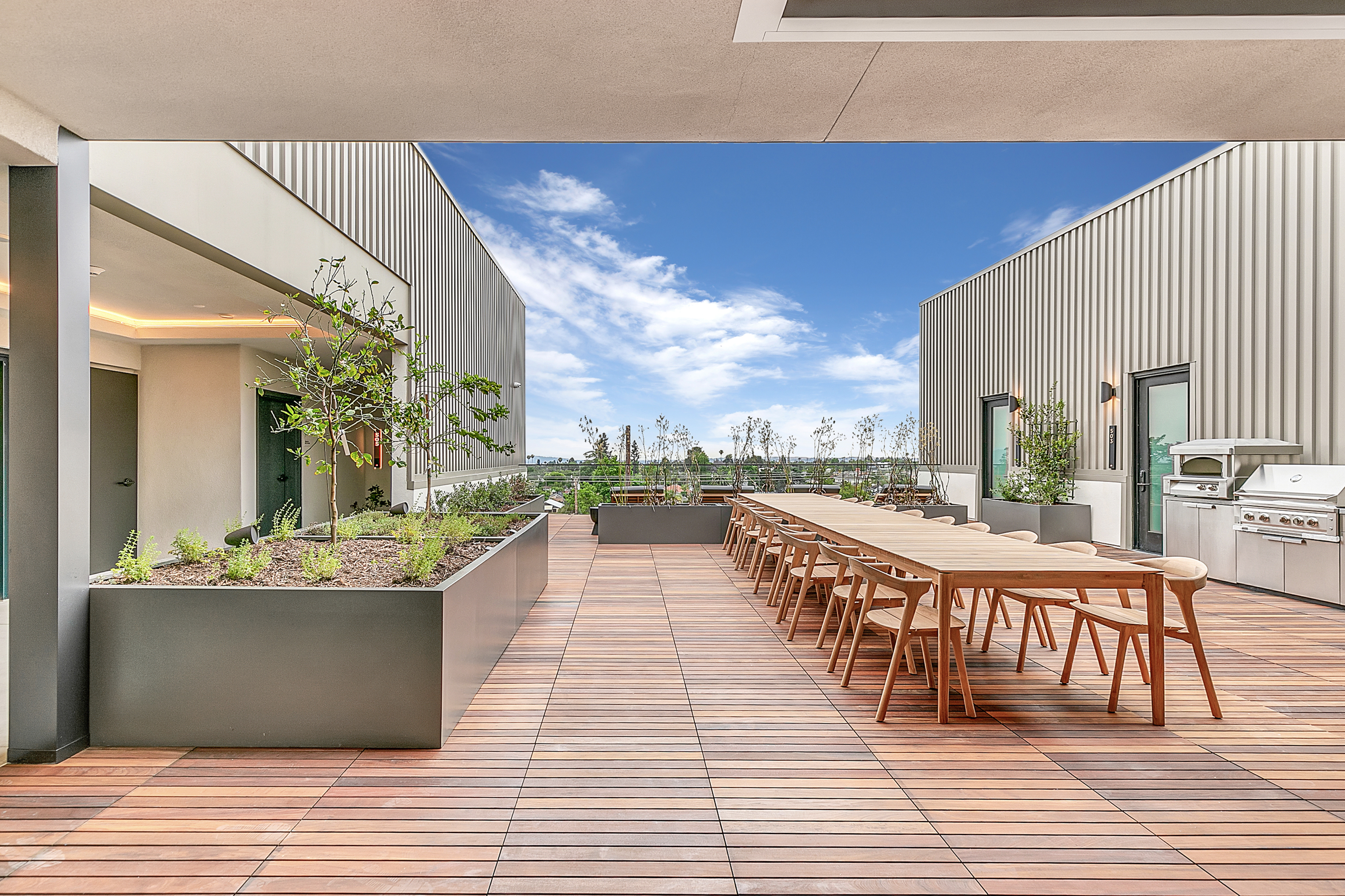 A Multifamily outdoor patio in Pasadena at The Rinrose, featuring a table and chairs.