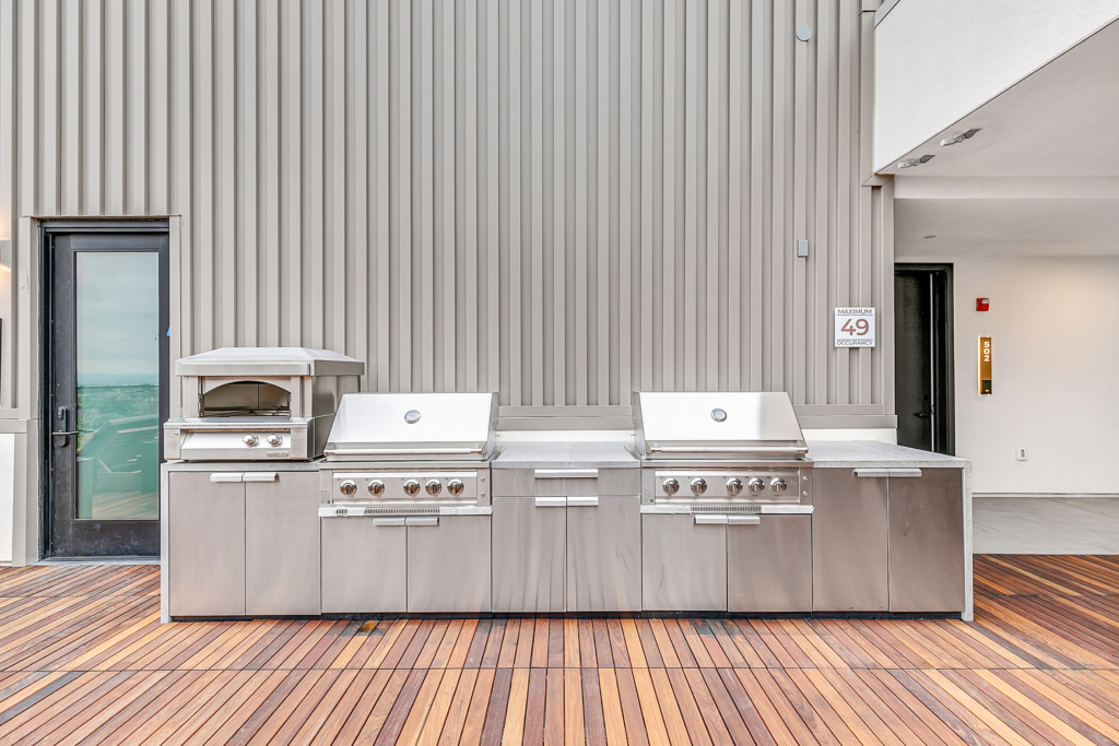 An outdoor kitchen in The Rinrose apartment with stainless steel appliances.