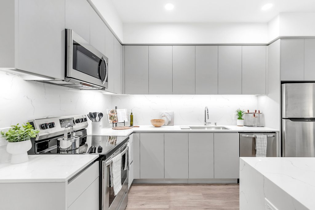 A multifamily apartment with white cabinets and stainless steel appliances.