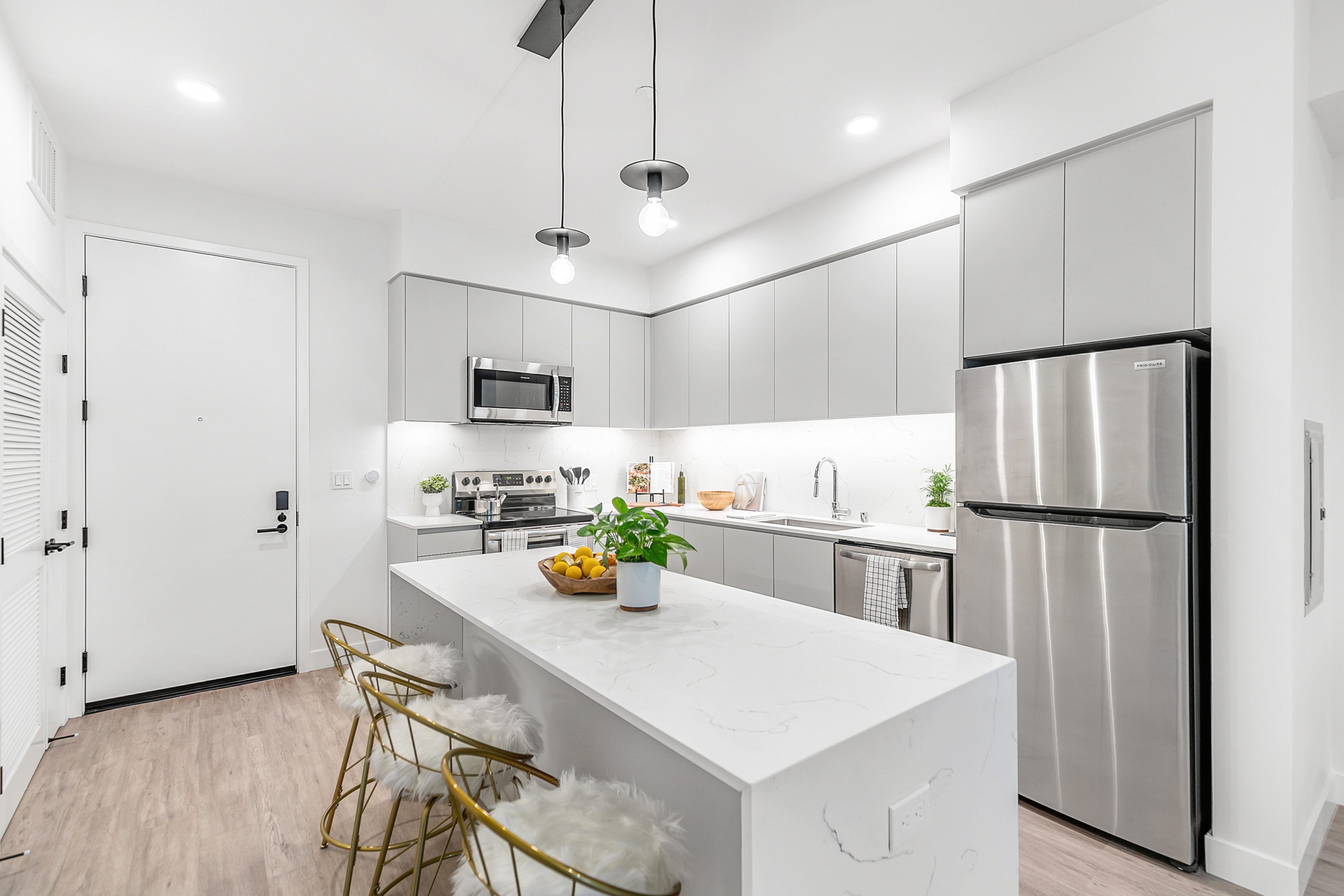 A kitchen in The Rinrose apartment complex in Pasadena with white cabinets and stainless steel appliances.